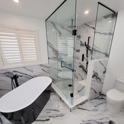 true form construction luxurious bathroom featuring a glass shower and a marble floor