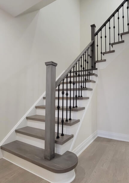 true form construction staircase with white wood floors and black railings creating a contrasting and elegant design