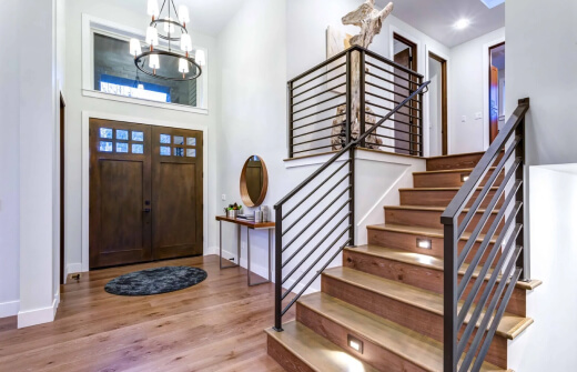 true form construction wooden staircase leading to a door in a foyer